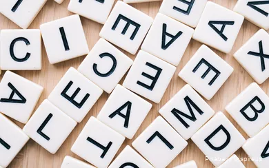 Several game pieces with letters are spread out on a table.